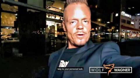 Wolf Wagner grinning confidently in nighttime street selfie promoting personal luck