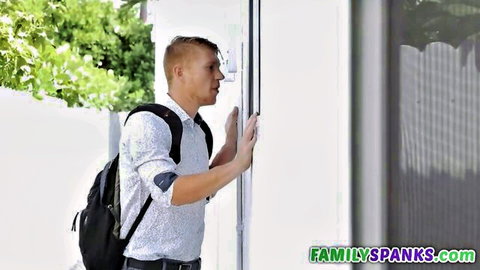 Young white stepbrother in shirt and jeans leaning against door, awaiting busty black stepsister