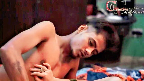 Sexy shirtless Indian guy groping his cock bulge on bed