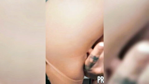 Blurry close-up of curvy pale woman's ass grabbed by tattooed hand in intimate pose