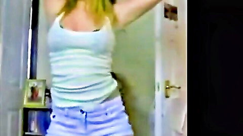 Blonde amateur Carey in tight white tank top and short purple shorts, arms raised