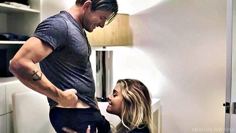 Kali Roses kneels teasing muscular man's waistband in intimate encounter