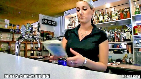 Hot Czech blonde bartender in black top at work bar counter