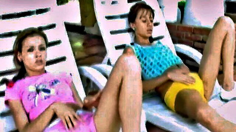 Two slim teen brunettes in sexy shorts teasing each other outdoors