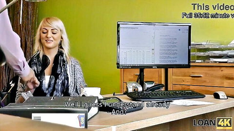 Blonde woman smiles at lender in office, teasing loan sex on desk