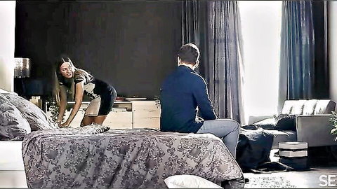 Eveline Dellai bends over in short black dress, teasing man on bed