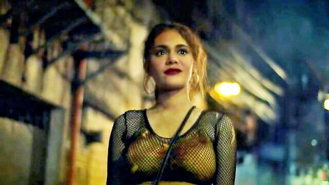 Seductive brunette with medium tits and hard nipples visible through sheer black fishnet top in dark alley