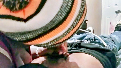 Woman's hand pulls down man's black underwear exposing his thick cock as he lies back wearing colorful beanie