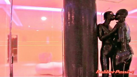 Latex rubber dolls kissing passionately in shiny fetish embrace