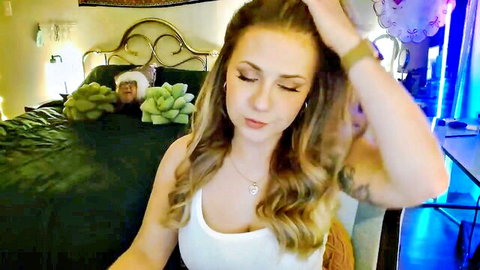 Sweetestlilly in white tank top, blonde waves, seductive gaze and cleavage tease