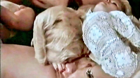Vintage lesbian intimate scene with two blonde women in lacy top embrace