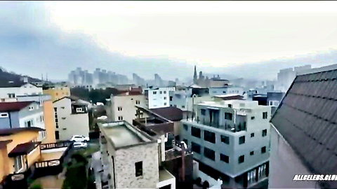 Aerial view of colorful urban rooftops and foggy city skyline with buildings