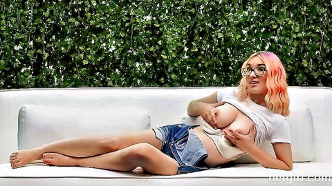 Pink-haired babe with glasses exposing big tits in denim shorts