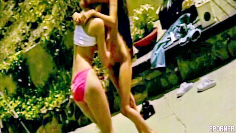 Vintage lesbian embrace: slim Asian babes in white top and pink shorts outdoors