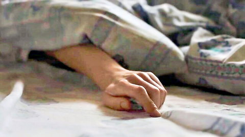Woman's hand fingering pussy under bed sheets closeup