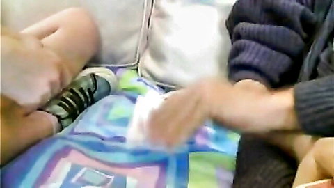 Older man intimately touching young woman's bare legs in amateur bedroom scene
