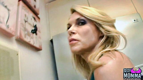 Blonde MILF with heavy eyeliner and glossy lips gazing seductively in Sexy Momma video