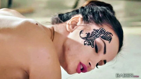 Alyssia Kent in black lace bodysuit, seductive profile with face art