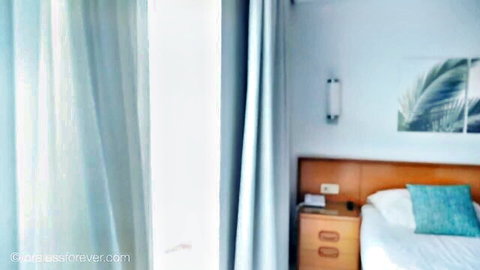 Blurry empty hotel bedroom interior with bed curtains and nightstand
