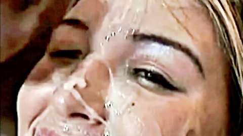 Blonde woman with cum-covered face in intense bukkake scene