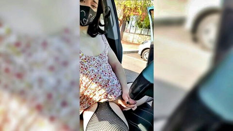Asian woman alone in car, floral top cleavage, fishnet stockings tease