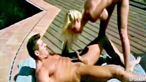 Busty blonde MILF performs outdoor blowjob on muscular guy by pool