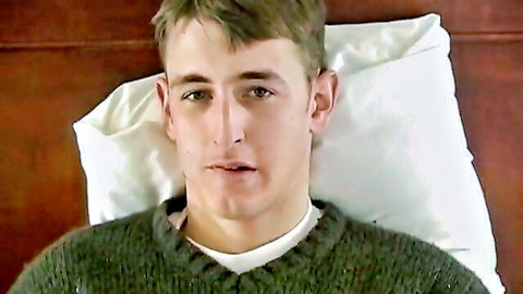 Young handsome man in sweater lying in bed, Ben & Greg gay scene