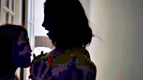 Silhouetted lesbians kissing tits in dark hotel hallway