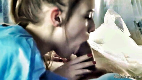Blonde woman in blue top sucking thick cock with red nails gripping shaft closeup