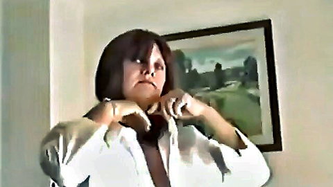 Toni Francis teasing striptease in open white shirt, showing cleavage
