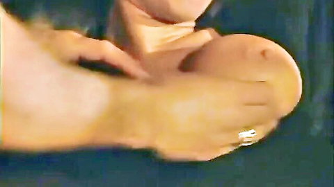 Close-up of large nude breast being squeezed by hand with ring
