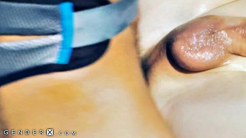 Closeup of oiled big trans cock with blue cock ring bands on fair skin