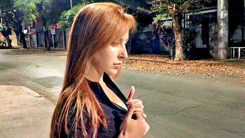 Melissa Lisboa redhead in black top on night street, teasing cleavage