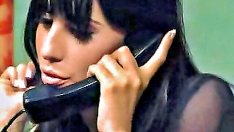 Jelena Jensen seductively on phone in sheer top, dark hair bangs