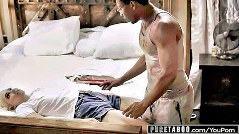 Muscular man lifts hot blonde's thigh in tight shorts on bed in taboo bedroom tease