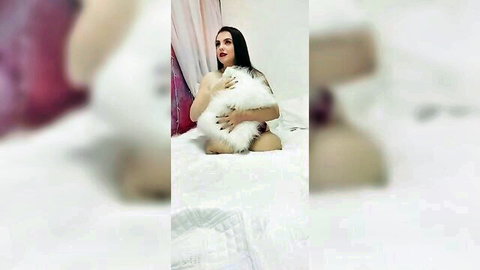 Nude brunette babe teasing by hugging fluffy white pillow over her tits and pussy on bed