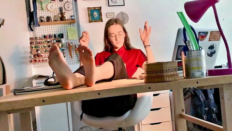 Brunette babe with glasses teases bare soles propped on desk in foot worship POV