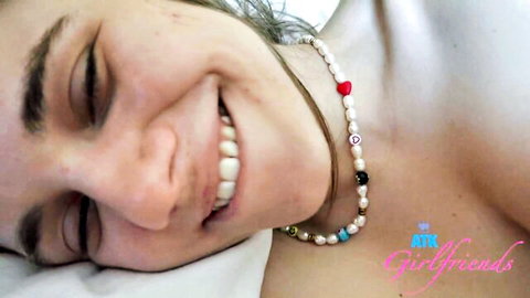 Smiling topless Rose Caarter in bed, pearl necklace