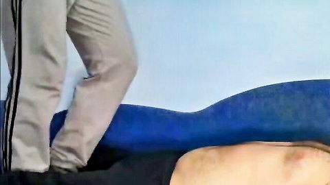 Young woman in pants trampling shirtless man's back in fetish scene