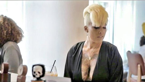 Jae Seymour in deep V-neck black top showing cleavage, blonde undercut hair