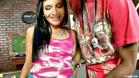 Young brunette smiles with BBC boyfriend in pink tank top at bar poker table
