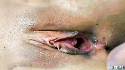 Closeup of fair-skinned woman's wet pink pussy spread wide open by fingers exposing inner hole