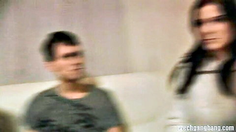 Blurry brunette in white top with man on couch in home gangbang preview