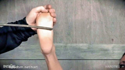 Busty tattooed slave foot punishment with rod in BDSM flogging