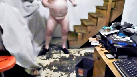 Chubby naked man standing solo exposing flaccid cock and balls in messy basement amateur