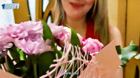Blonde amateur MILF smiling in red dress holding pink flowers