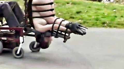 Bound BDSM slave in outdoor wheelchair restraint for missionary anal