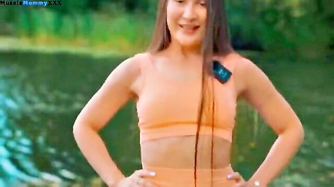Fit athletic woman in orange yoga outfit stretching by lake