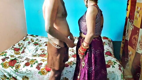 Shirtless Indian man gropes his cock bulge through shorts in front of bride in shiny purple saree