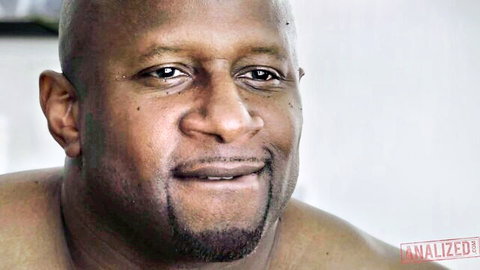 Shirtless bald muscular Black man with goatee smiling closeup portrait